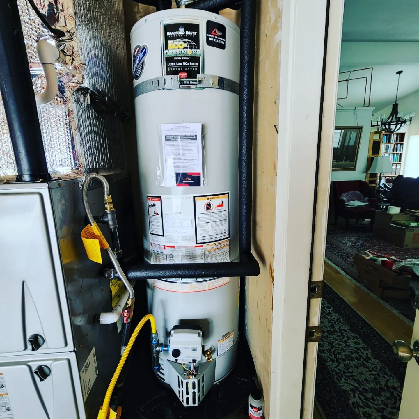 A water heater is sitting in a room next to a door