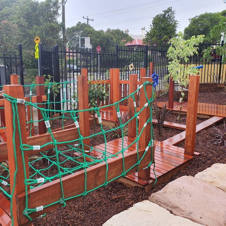 A Wooden Bridge With a Green Rope Fence Around It — Garden Vogue in Charlestown, NSW
