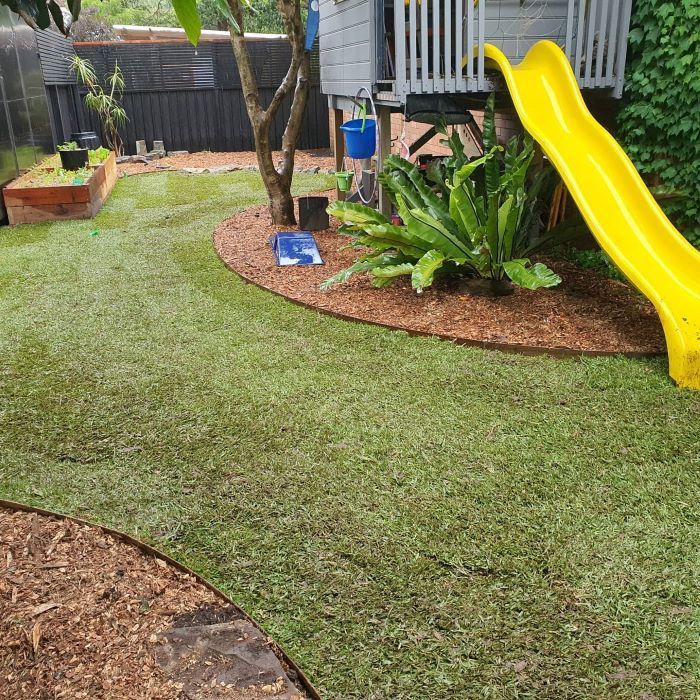 A Yellow Slide is in a Backyard Next to a Tree House — Garden Vogue in Charlestown, NSW