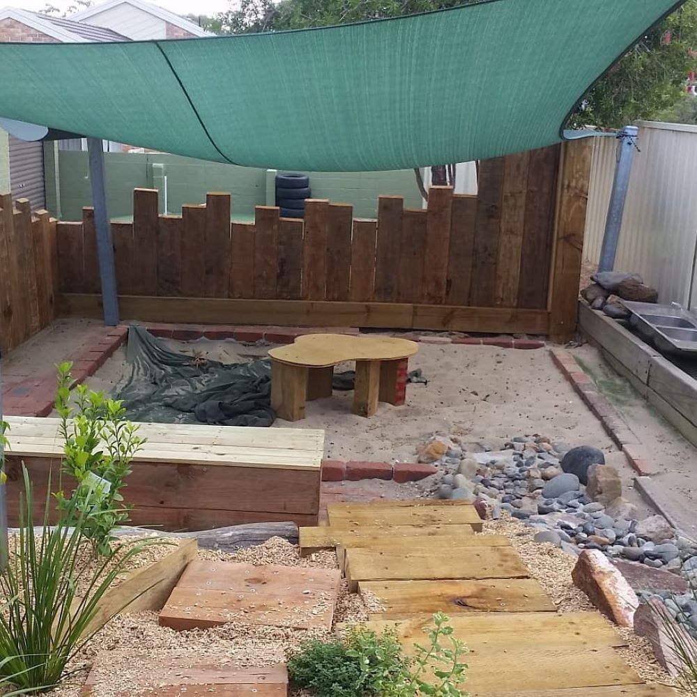 A Wooden Sandbox With a Green Umbrella Over It — Garden Vogue in Charlestown, NSW