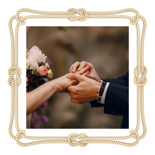 A man is putting a wedding ring on a woman 's finger.