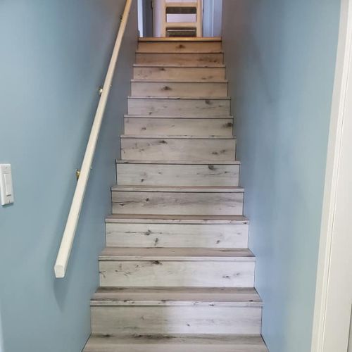 New vinyl plank stairs leading down into a basement.