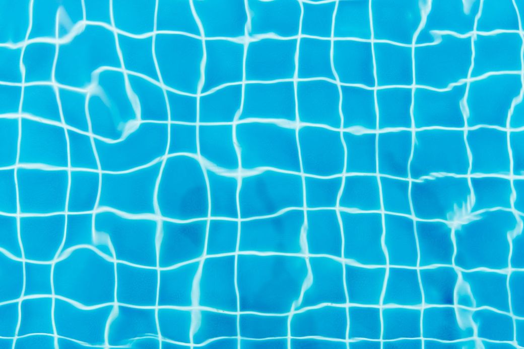 Blue pool water with white reflections and ripples from a netted surface