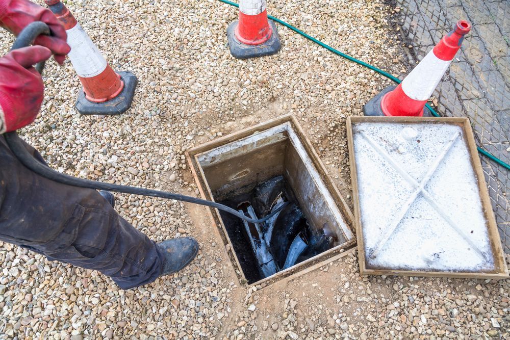 Person Clearing a Drain, Orange Cones Around — 2 Foote Plumbing & Gas in Darwin, NT