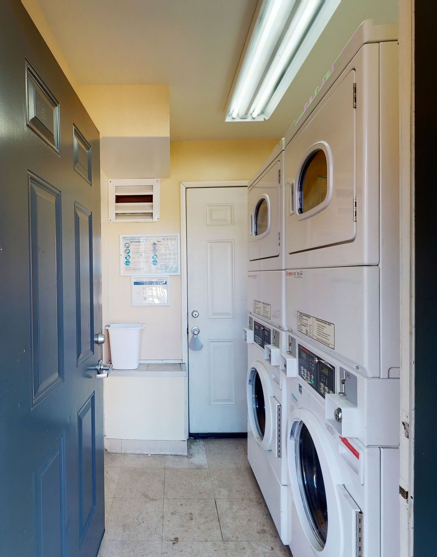 A laundry room with washers and dryers stacked on top of each other