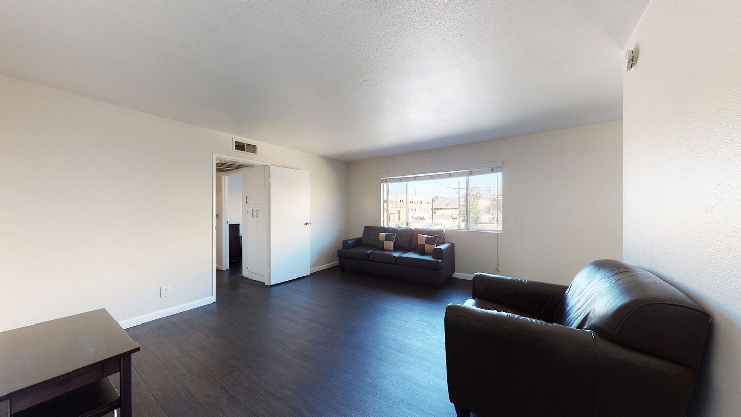 A living room with a couch , chair , table and window.