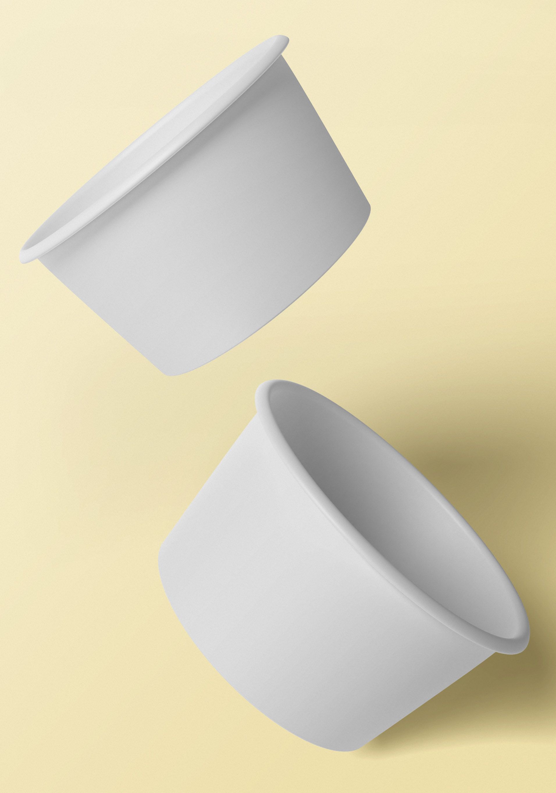 Two white paper cups against a yellow background, one above the other, slightly angled.