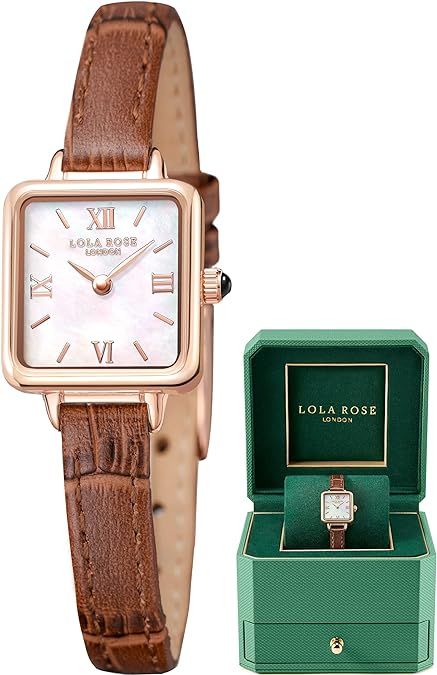 a square watch with a brown leather strap and a green box .