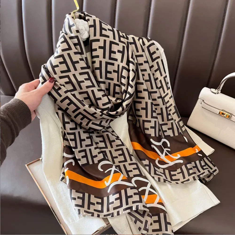 a person is holding a scarf with a fendi logo on it .