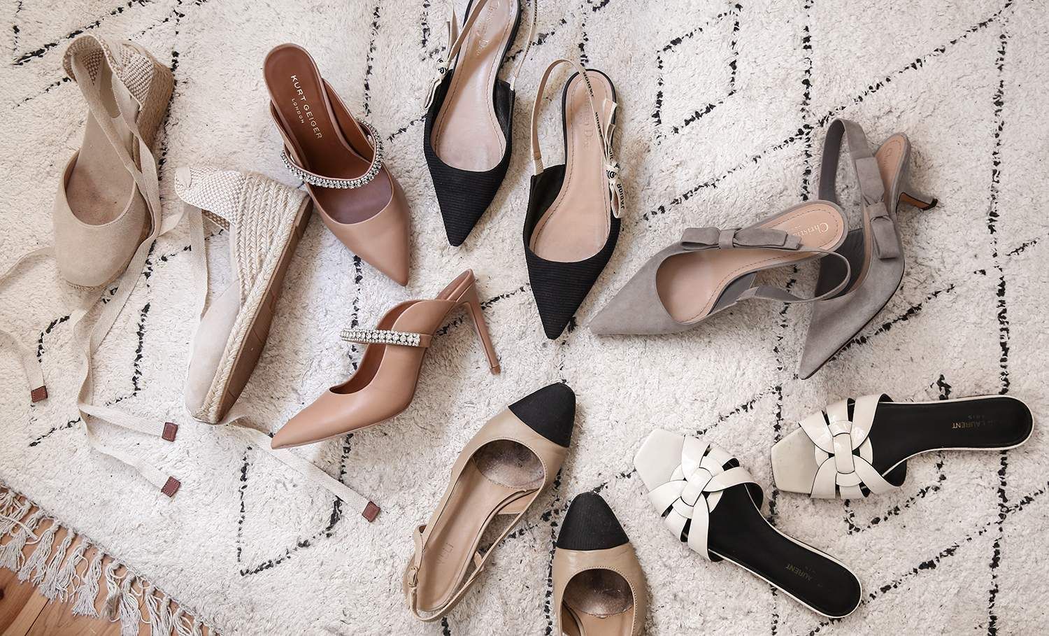 a variety of shoes are sitting on a rug on the floor .
