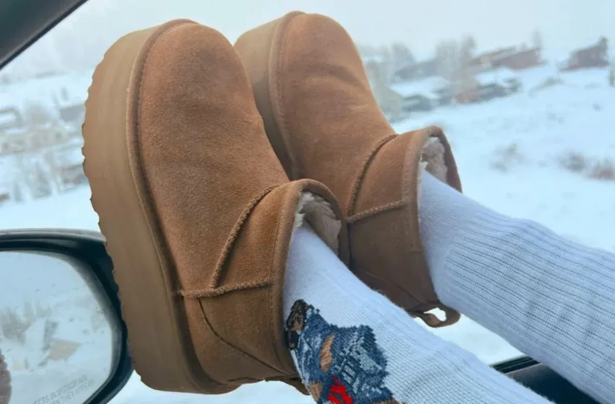 a person wearing ugg boots and socks is sitting in a car