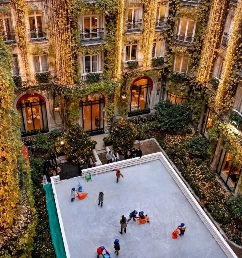 a group of people are ice skating in front of a building