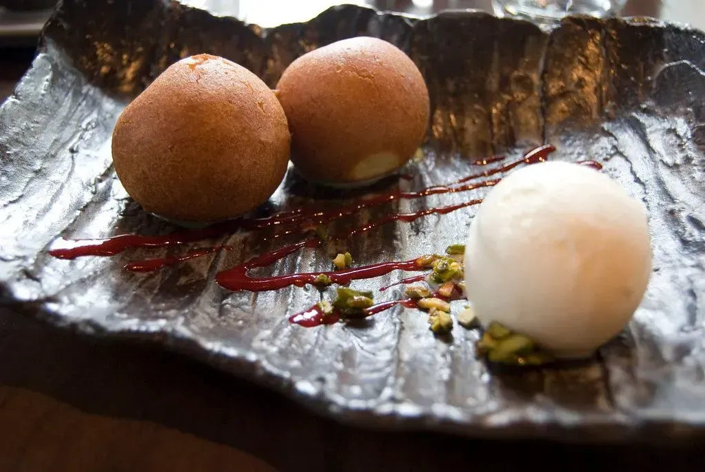 a close up of a plate of food with two balls and a ball of ice cream