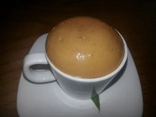 a close up of a cup of coffee on a saucer