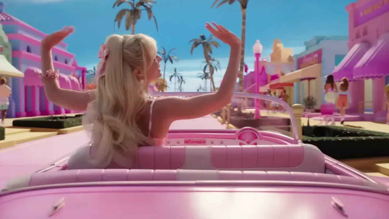 a barbie doll is sitting in a pink car .