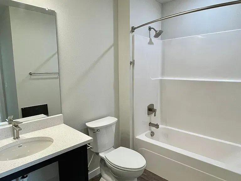 A bathroom with a toilet , sink , and bathtub.