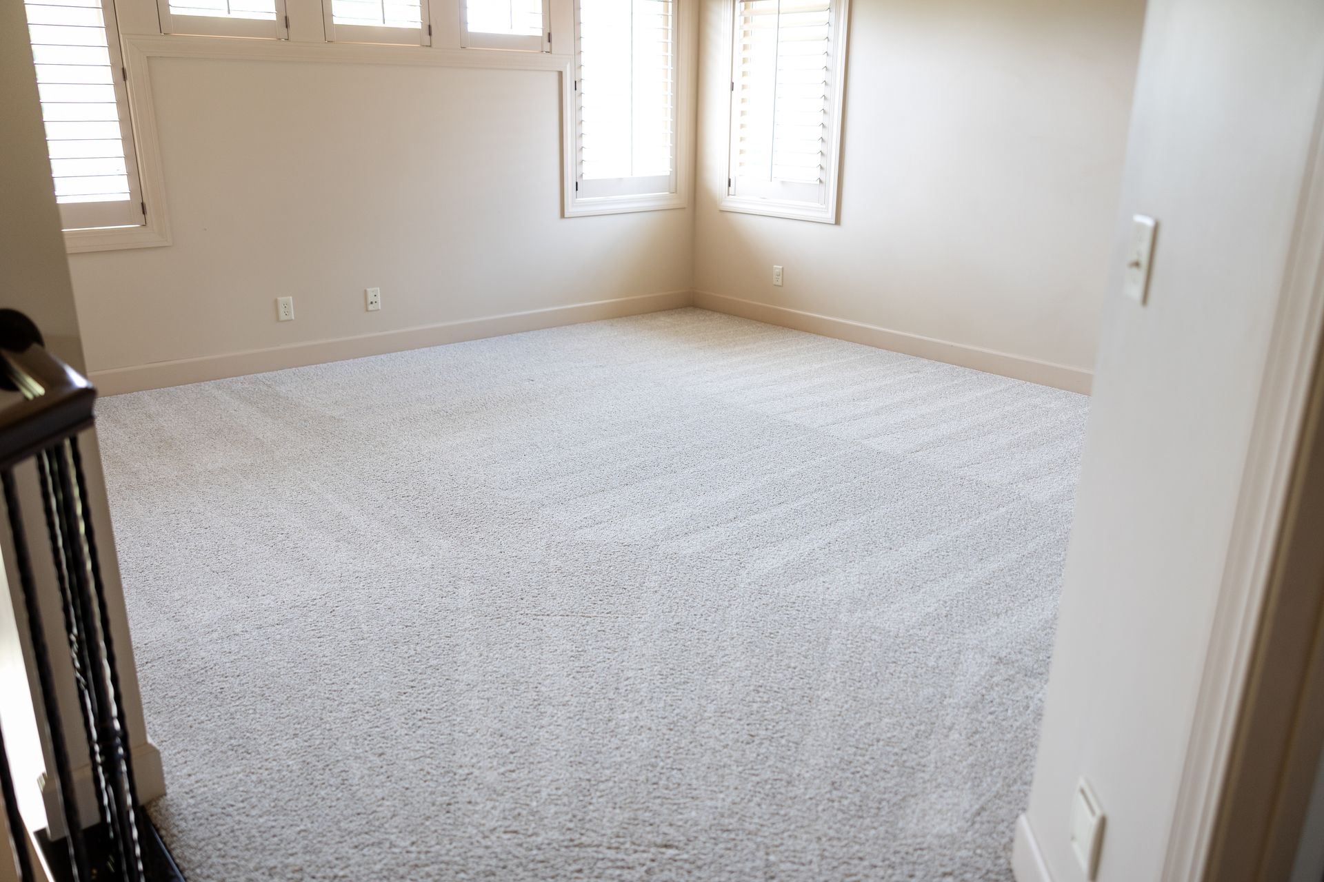 Clean carpet with carpet lines in a beige room. Clean carpet with carpet lines in a beige room.