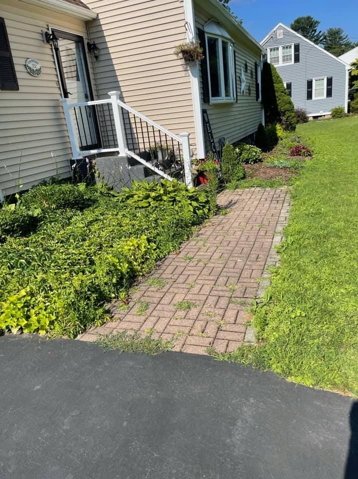 There is a brick walkway leading to the front of a house.