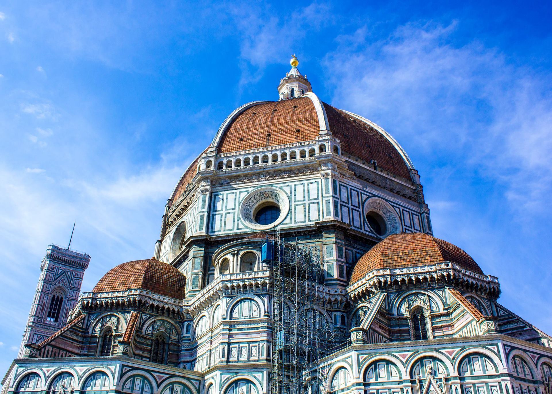 A large building with a dome on top of it against a blue sky.