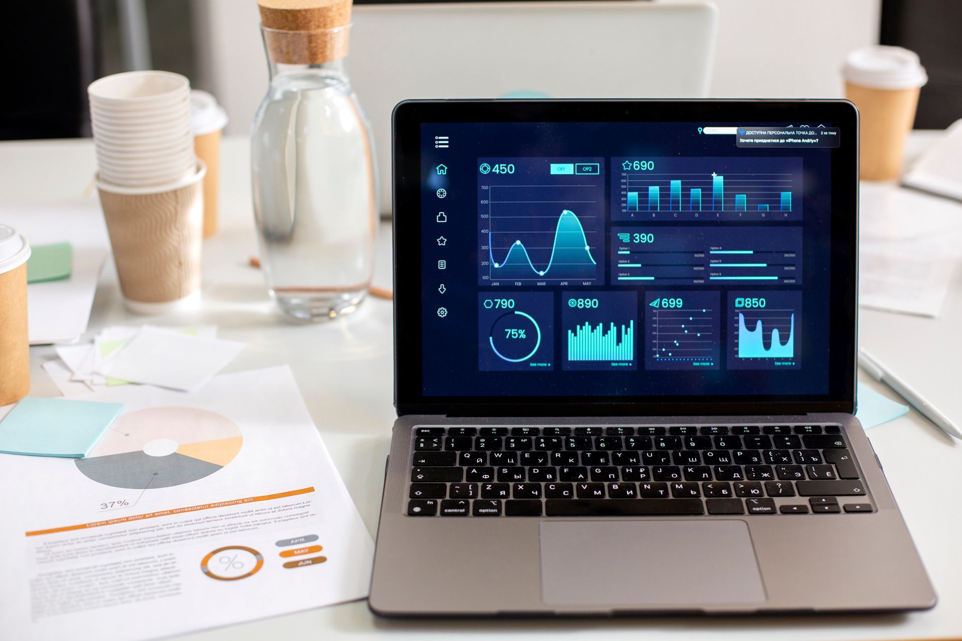 Notebook com painel de gráficos e dados de desempenho em mesa de trabalho
