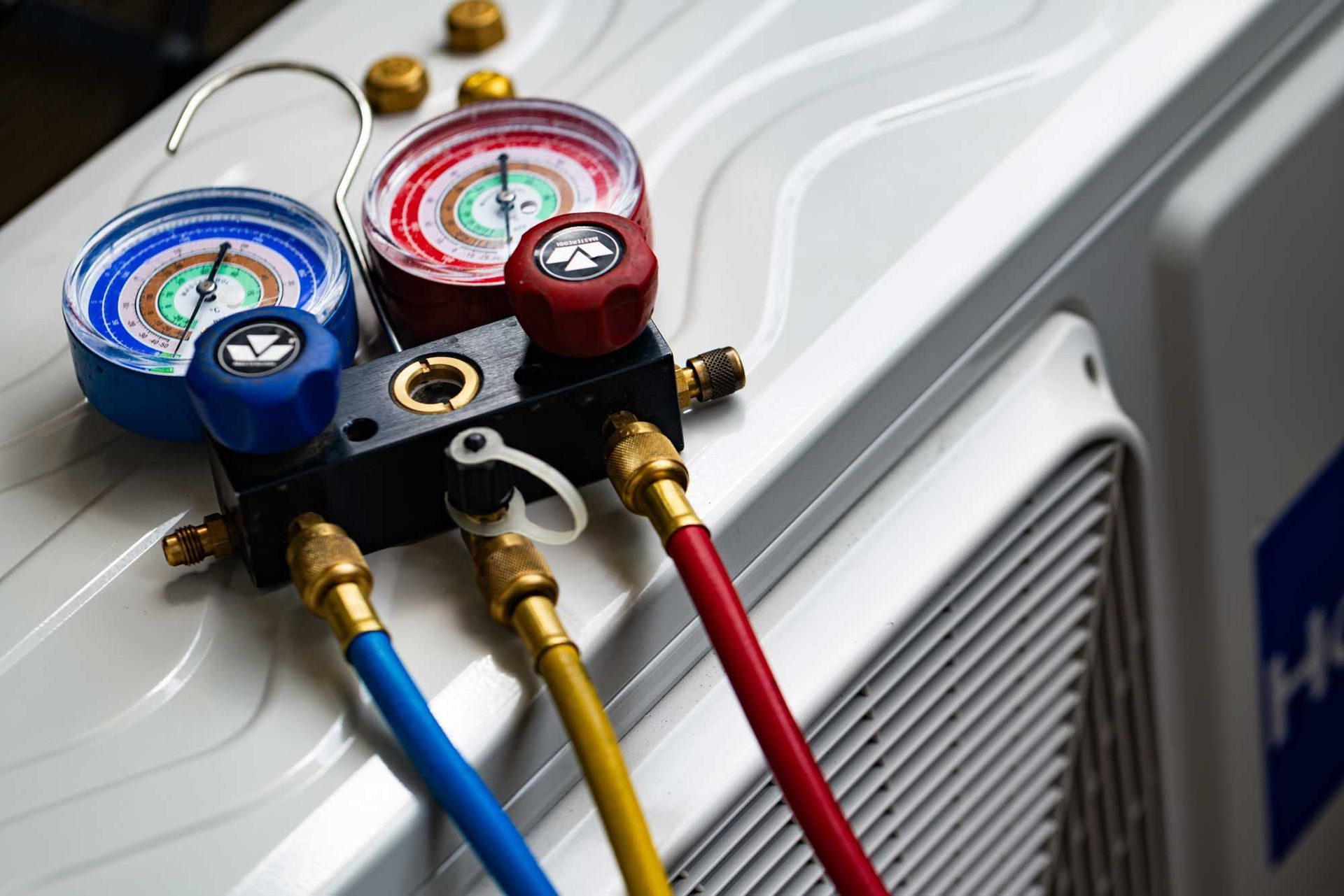 Emergency ac repair service showing HVAC pressure gauges connected to outdoor air conditioning unit. Emergency ac repair service showing HVAC pressure gauges connected to outdoor air conditioning unit.