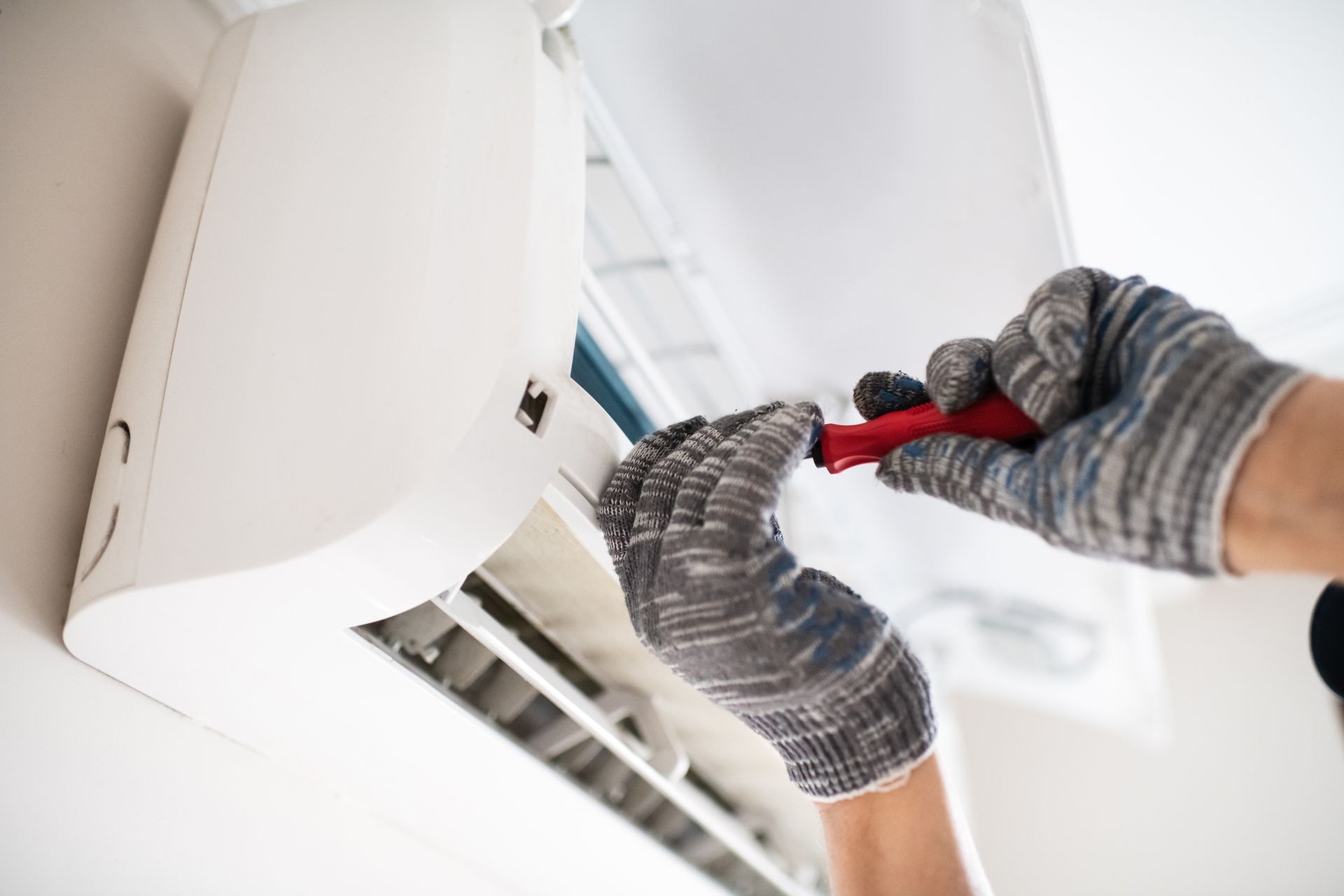 A technician repairs a wall-mounted air conditioner A technician repairs a wall-mounted air conditioner