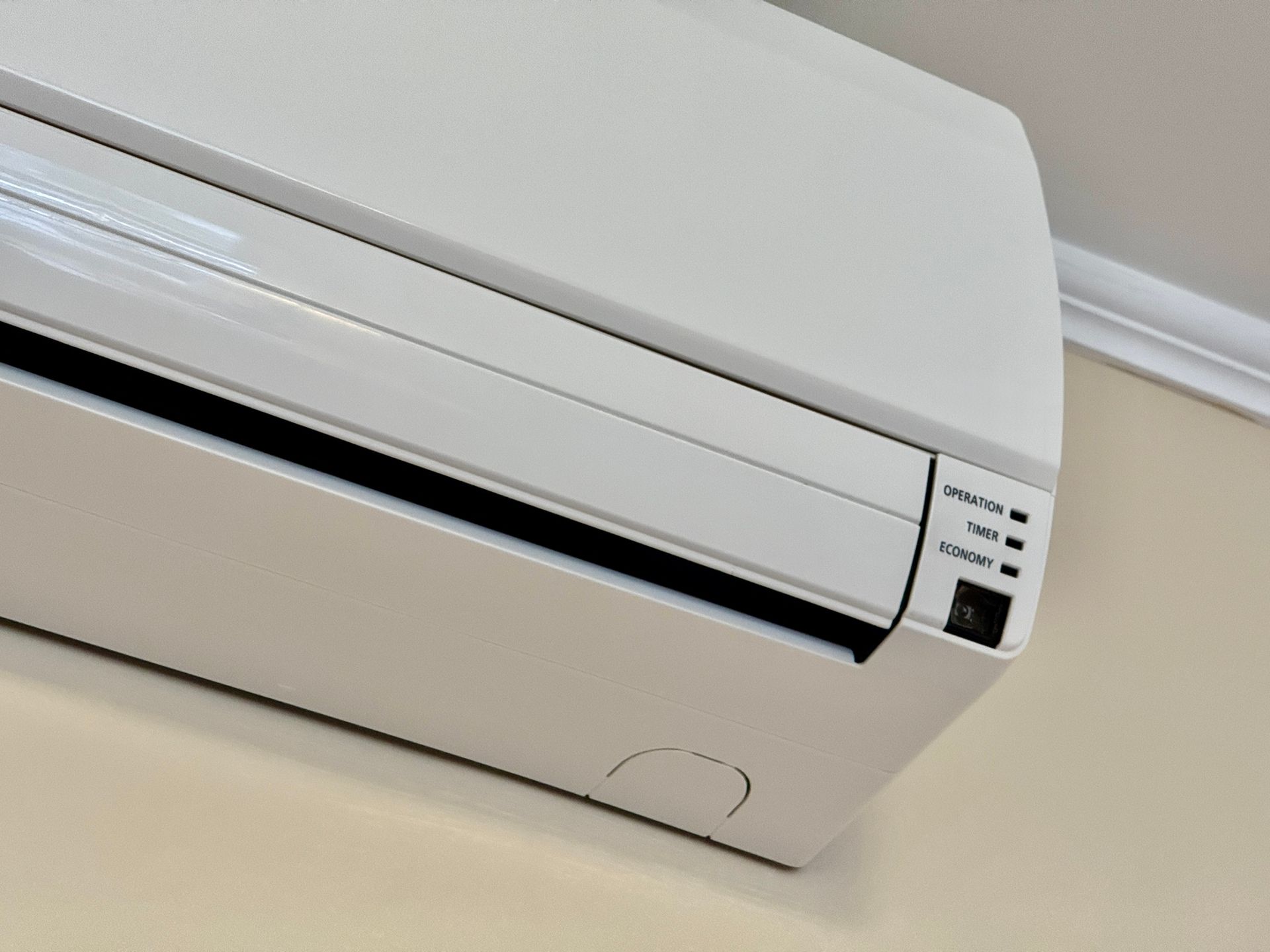 A close up of a white air conditioner on a wall