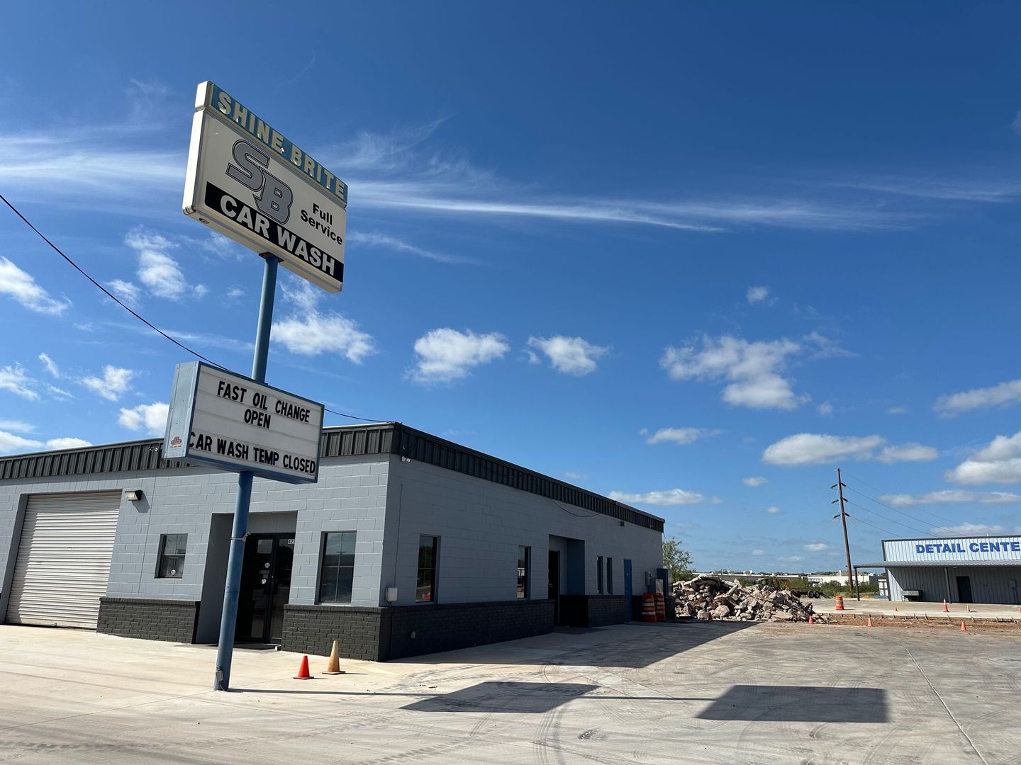 Car wash building with a blue sign and a clear sky.