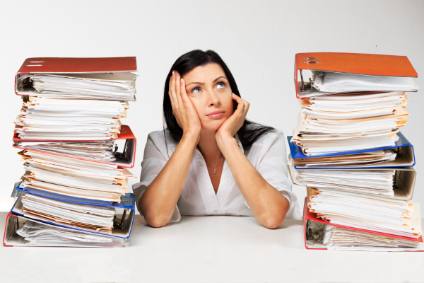 Woman with stacks of folders representing a person feeling overwhelmed about the documents to submit for a uk visa application