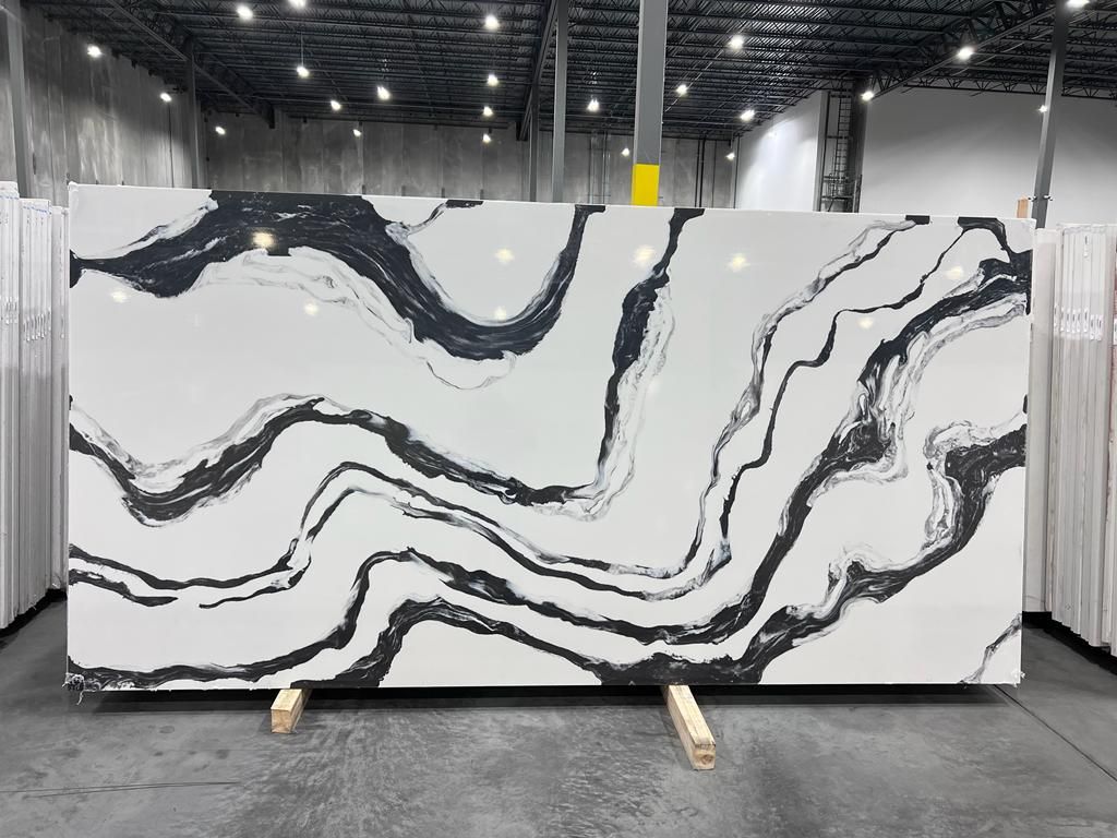 Large white countertop slab with black veining, displayed in a warehouse setting.