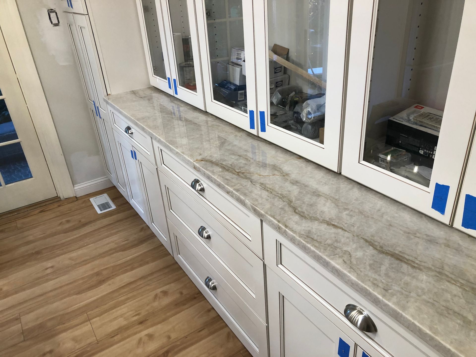 White cabinets with a marble countertop in a kitchen.