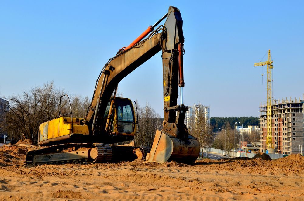A Large Yellow Excavator is Sitting on Top of a Dirt Field — Dino's Bobcat–Bitumen & Excavator Hire in Wondai, QLD