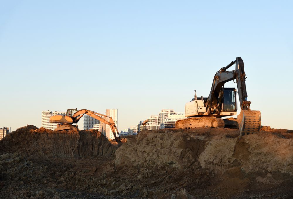 A Couple of Excavators Are Working on a Construction Site — Dino's Bobcat–Bitumen & Excavator Hire in Kingaroy, QLD