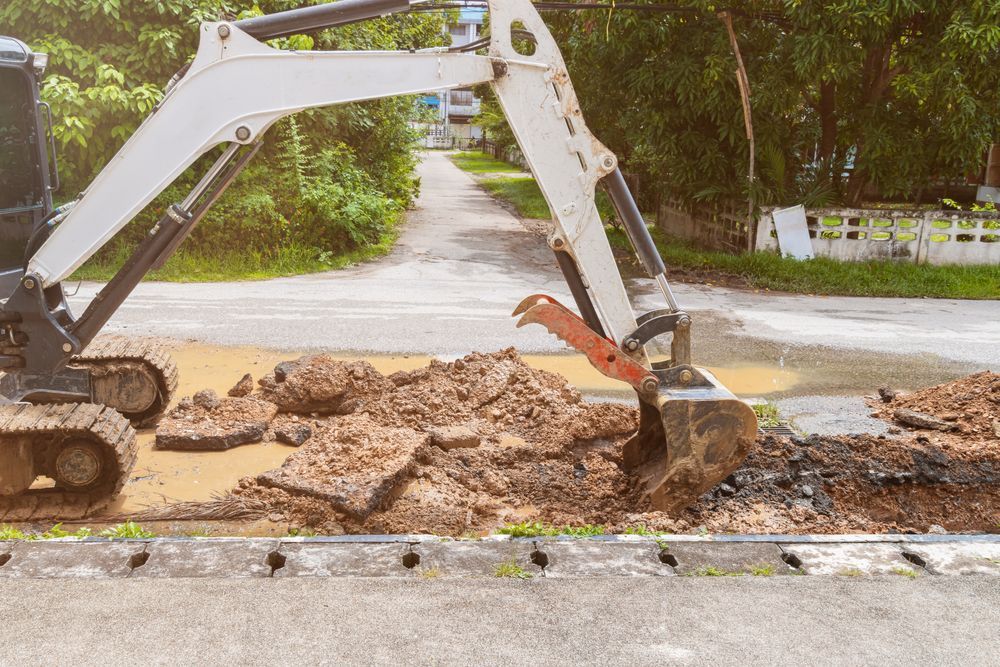 An Excavator is Digging a Hole in the Ground — Dino's Bobcat–Bitumen & Excavator Hire in South Burnett, QLD