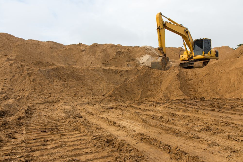 A Yellow Excavator is Digging in a Pile of Dirt — Dino's Bobcat–Bitumen & Excavator Hire in Cushnie, QLD