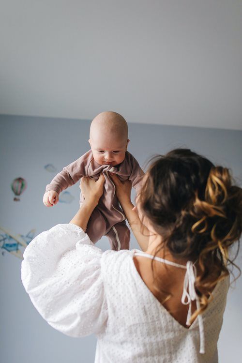mother and infant playing in nursery