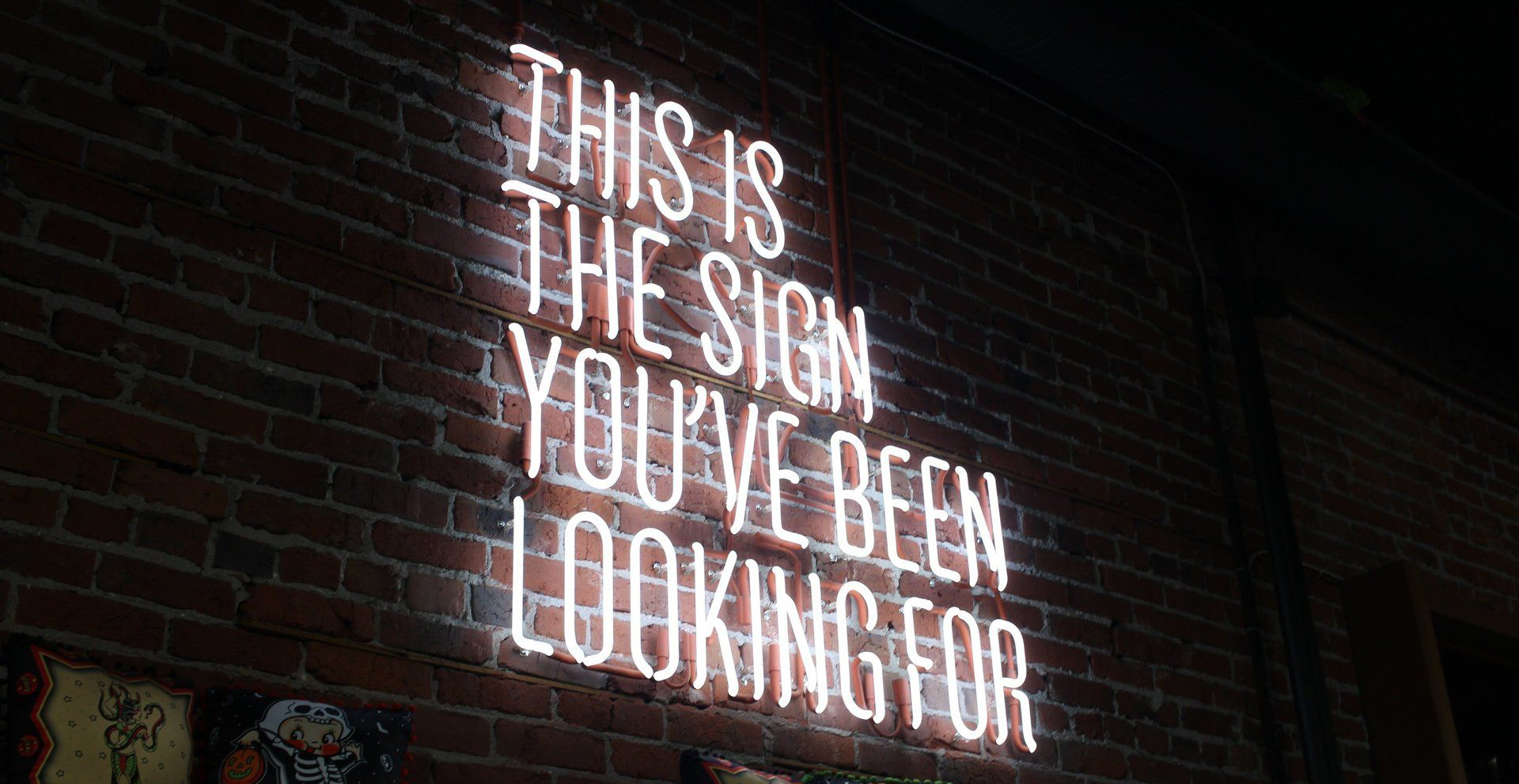Neon sign on brick wall: 