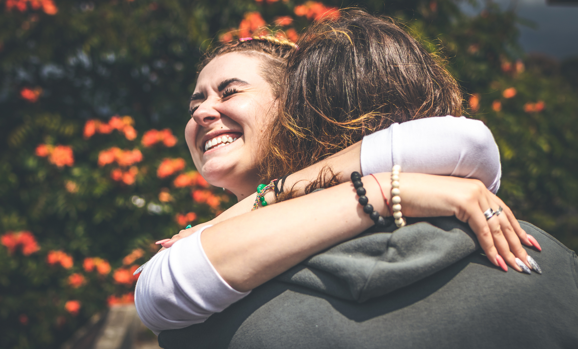 A woman is hugging a man and smiling.