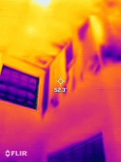 Thermal view of a window and ceiling in orange and purple, with a 52.3° temperature marker.
