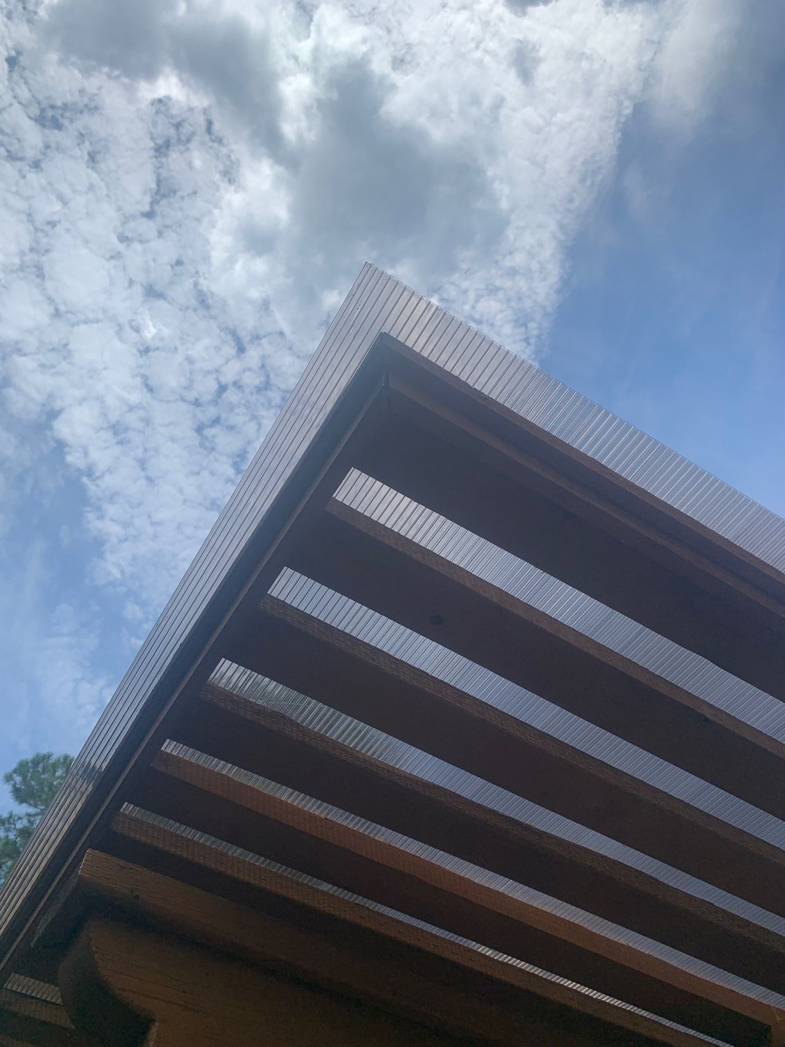 Low-angle view of a modern building facade against a cloudy blue sky