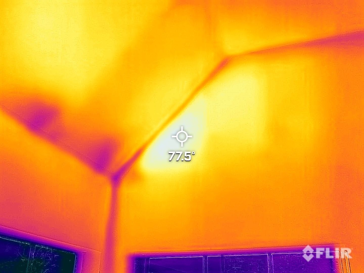 Thermal view of an interior ceiling corner with a 775° hotspot and FLIR watermark