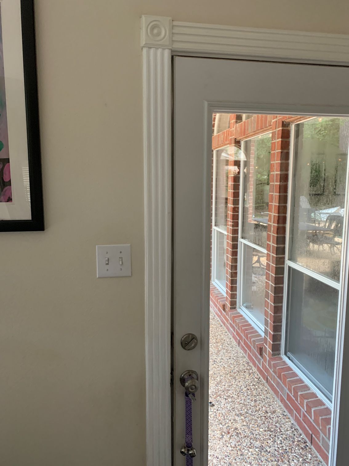 Inside view of a glass door with brick patio and building visible outside