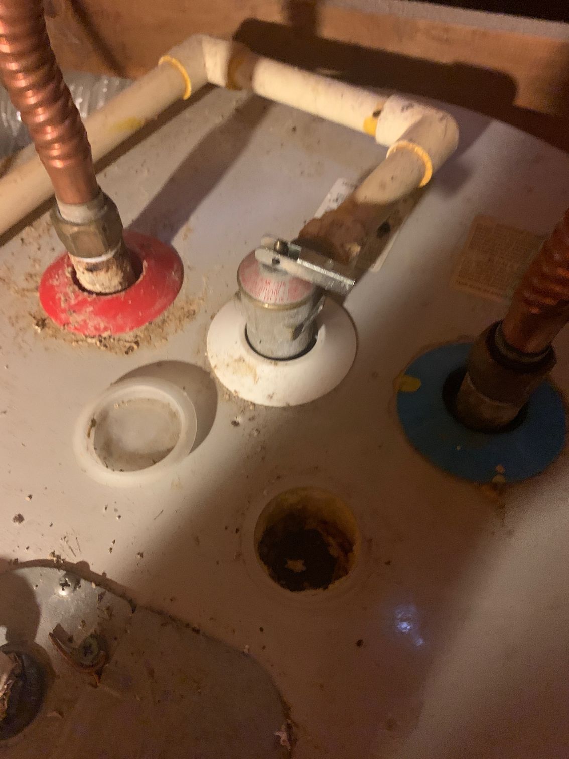 Under-sink plumbing with copper pipes, shutoff valves, and drain openings on a white surface
