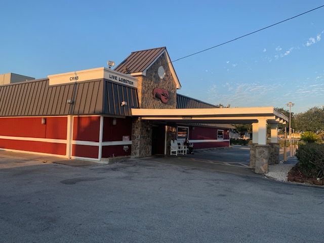 Red barn-style building with covered drive-through entrance at sunset