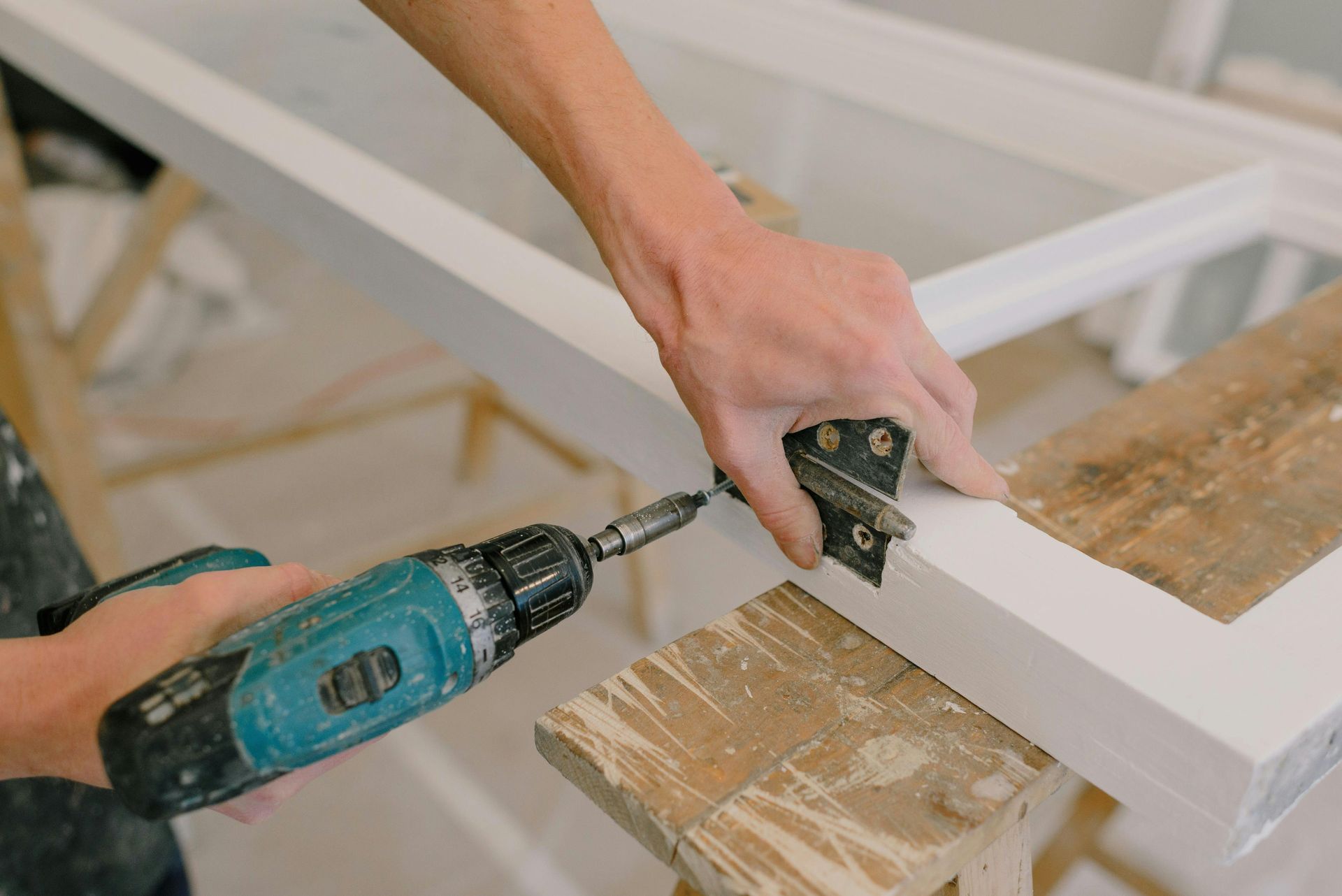 A person is using a drill on a piece of wood.