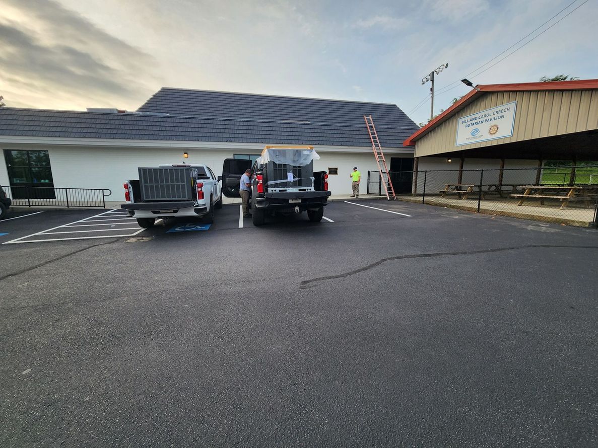 Cars parked outside a building with a partially collapsed roof after storm damage