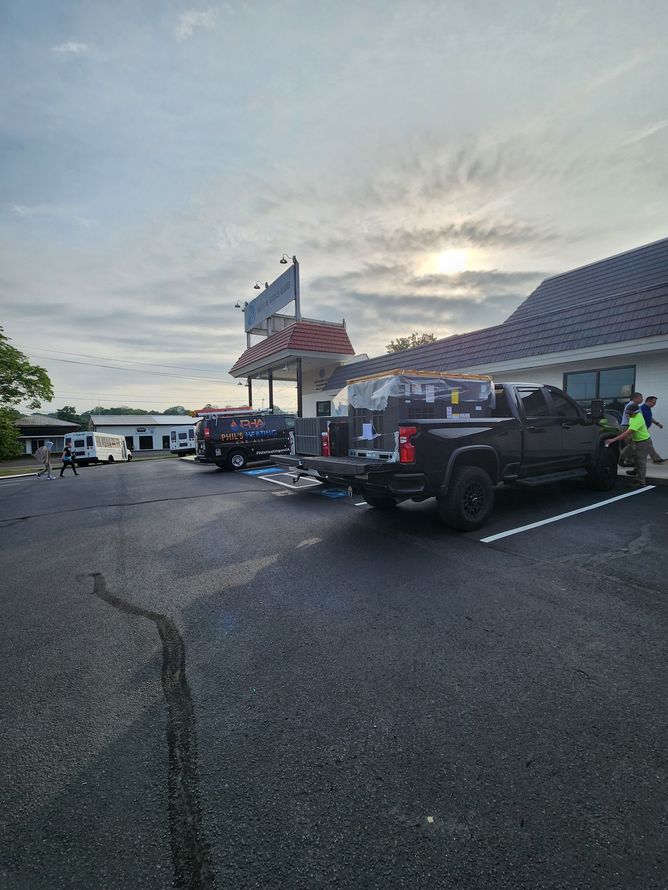 Several off-road vehicles parked outside a building at dusk under a cloudy sky.