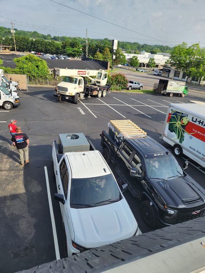Parking lot with white SUVs, a black truck, and a person in a red shirt near the left edge.