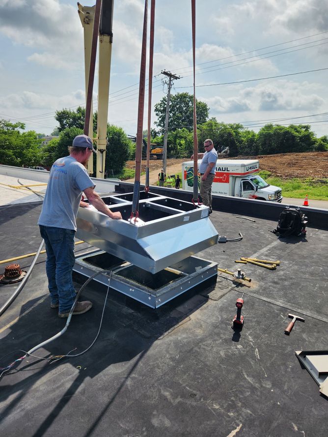 Workers assembling a large metal structure outdoors on a paved lot beside a parked truck