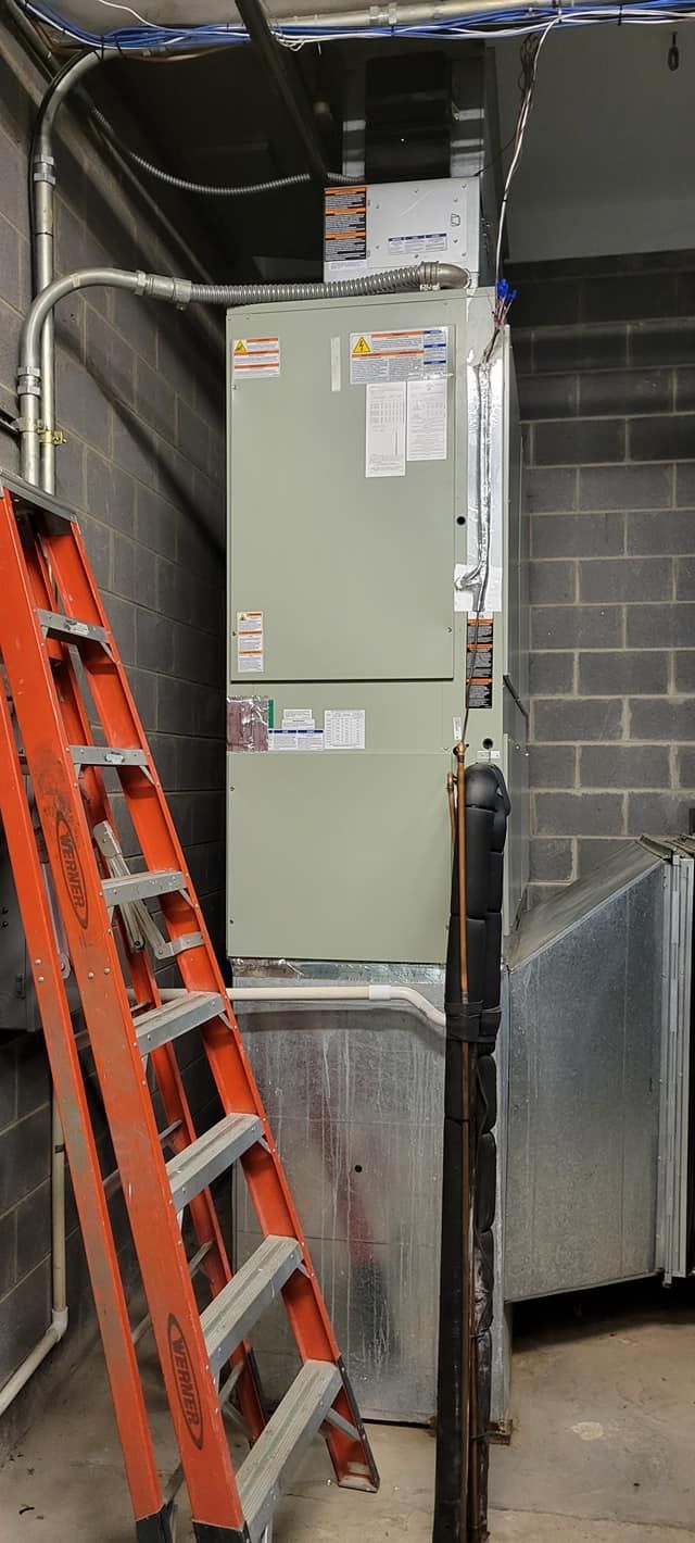 Basement electrical panel with conduit and an orange ladder leaning beside it